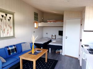 a living room with a blue couch and a bed at Attefallshus på Långnäs in Bollnäs
