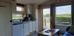 a kitchen with white cabinets and a table and a window at Attefallshus på Långnäs in Bollnäs