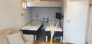 a room with two beds and a couch in it at Attefallshus på Långnäs in Bollnäs
