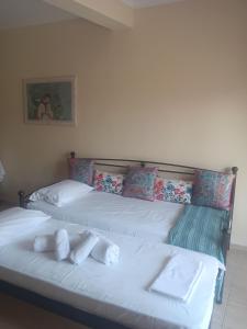 two beds in a bedroom with white sheets and pillows at Melinas Home in Chrysoupolis