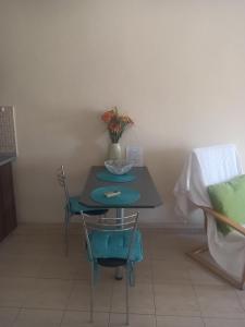 a small table with two chairs and a vase with flowers at Melinas Home in Chrysoupolis