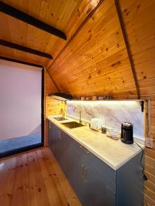 a kitchen with a sink and a large window at Panorama Cottage in Erge