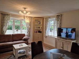 a living room with a couch and a flat screen tv at Goting-Sonne in Borgsum