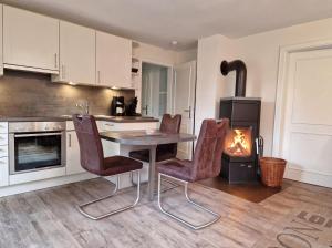 a kitchen with a table and chairs and a stove at Goting-Sonne in Borgsum
