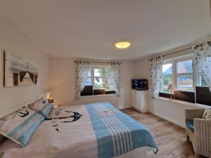 a bedroom with a bed and two windows at Goting-Sonne in Borgsum +13 photos