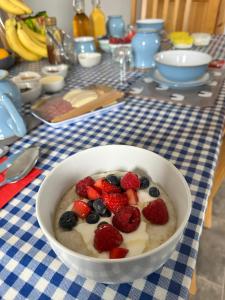 a bowl of cereal with fruit on a table at Trumpan Cottage Bed & Breakfast in Trumpan