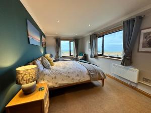 a bedroom with a bed and a large window at Trumpan Cottage Bed & Breakfast in Trumpan