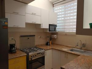 a kitchen with white cabinets and a stove top oven at Yanahuara Urb Ibargüen in Arequipa