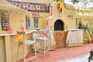 a bar outside of a house with two stools at Hacienda Oliva in Hammam Sousse