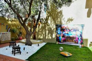 a garden with a tree and a table and a chair at Hacienda Oliva in Hammam Sousse