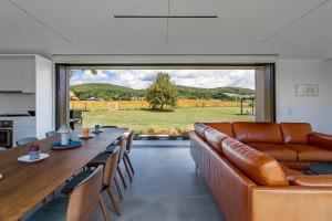 a living room with a couch and a table with chairs at Valley View - Renovated Cottage New Addon and Pool in Copake