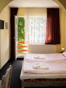a bedroom with a bed and a large window at Семеен Хотел ,,Царева Ливада'' in Tsareva Livada