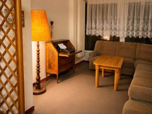 a living room with a couch and a table and a lamp at Семеен Хотел ,,Царева Ливада'' in Tsareva Livada +20 photos