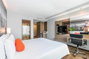 a bedroom with a white bed and a desk and a television at The- Luxury Enclave Plaza Near IGI Airport Delhi in New Delhi