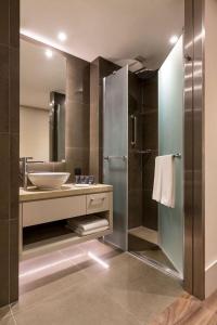 a bathroom with a sink and a glass shower at The- Luxury Enclave Plaza Near IGI Airport Delhi in New Delhi +32 photos
