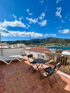 a patio with two chairs and a table on a roof at Apartaments Tramuntana in Port de la Selva