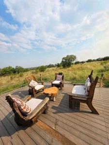 a wooden deck with chairs and tables on a field at Olopiro Stay in Maasai Mara National Reserve +32 photos