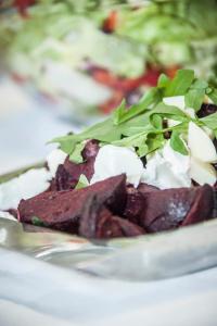a plate of food with greens on top of it at Löydön Kartano Villas in Mikkeli