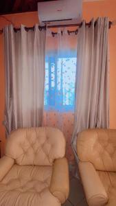 a room with two chairs and a window at Résidence Le Refuge de Mbangue in Kofa