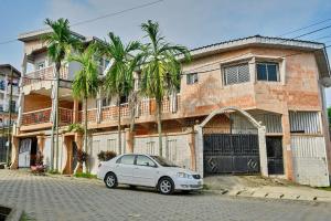 a white car parked in front of a building at Résidence Le Refuge de Mbangue in Kofa