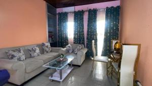 a living room with a couch and a table at Résidence Le Refuge de Mbangue in Kofa