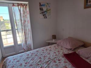 a bedroom with a bed and a window at Entre Terre et Mer in Malestroit