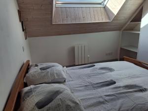 a small bedroom with a bed with a window at Entre Terre et Mer in Malestroit
