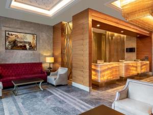 a lobby with a red couch and a waiting room at Mövenpick Hotel & Thermal Spa Bursa in Bursa