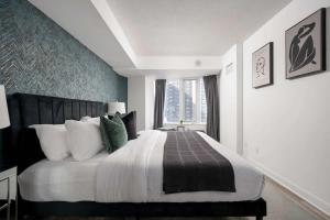 a bedroom with a large bed and a window at Modern King Suite Steps to Eaton Centre in Toronto