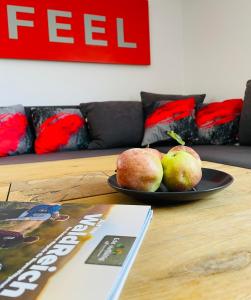 a plate of fruit on a table with a book at LohainsLodge in Burbach +5 photos