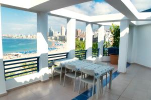 a balcony with a table and chairs and a view of the beach at Apartamentos la barca in Benidorm