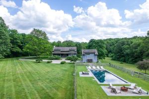 an aerial view of a house with a swimming pool at Whimsy Woods - 14 Acre Millbrook Estate with Pool in Millbrook