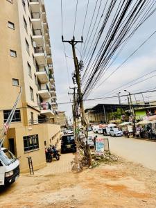 a pole with power lines on it next to a building at Kasarani trm in Nairobi