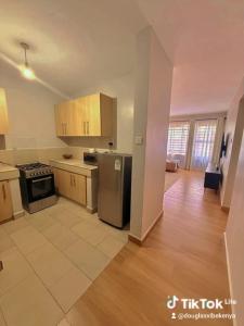 a kitchen with stainless steel appliances and wooden cabinets at Kasarani trm in Nairobi