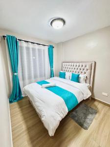 a bedroom with a large bed with blue curtains at Kasarani trm in Nairobi