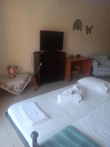 a bedroom with a bed and a tv and a table at Melinas Home in Chrysoupolis +11 photos