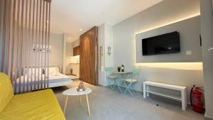 a living room with a couch and a tv on the wall at Magdalena Elegant Studios in Neoi Epivates