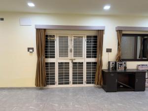 a room with a large glass door with a microwave at Desai Villa - Pawna Lake in Wadgaon