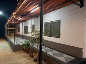 a building with potted plants on the side of it at Desai Villa - Pawna Lake in Wadgaon