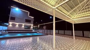 a large building with a swimming pool at night at Desai Villa - Pawna Lake in Wadgaon