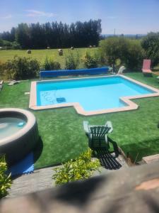 a swimming pool in a yard with two chairs next to it at Mas de Grezes in Gaillac