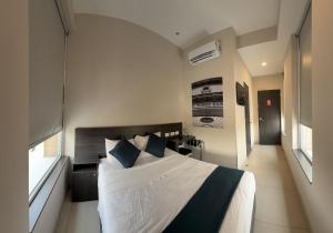 ein Schlafzimmer mit einem großen Bett und blauen Kissen in der Unterkunft Vive Place in Aguascalientes
