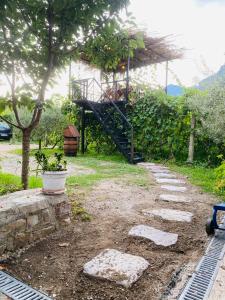 a garden with a staircase leading to a house at Guest House Castle in Koman +5 photos