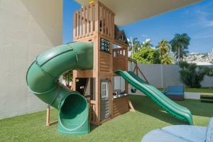 a playground with a slide and a clock tower at Ocean View Condo with Resort Amenities in Acapulco