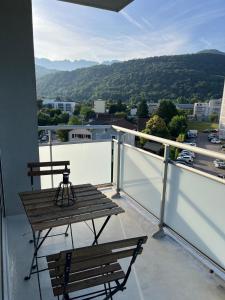 a balcony with a bench and a view of a city at Studio Le Mûrier in Saint-Martin-dʼHères