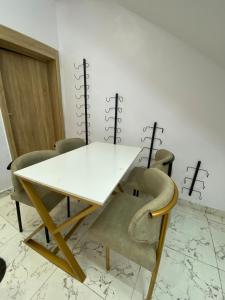 a white table and chairs in a room at Emilomo Luxury Apartment in Idowu +3 photos