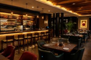 a restaurant with tables and chairs and a bar at Hotel The Caves Near IGI Airport Delhi in New Delhi