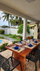 a wooden table with blue dishes on it on a patio at Casa Estrela Azul in Pitimbu