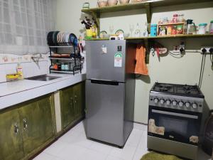 a kitchen with a refrigerator and a stove at Victorious place in Kitale