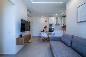 a living room with a blue couch and a kitchen at The Simon Residences - Marina Escape in Olhão